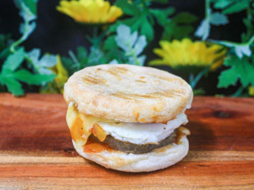 Breakfast English muffin with sausage, fried egg, cheese and tomato relish 